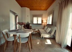 尼亚·卡利克拉提亚Enalio Beach House的客厅配有桌椅和沙发