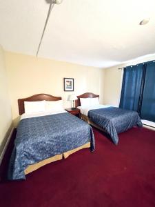 尼亚加拉瀑布Fairway Inn by the Falls的酒店客房,设有两张床,铺有红地毯。