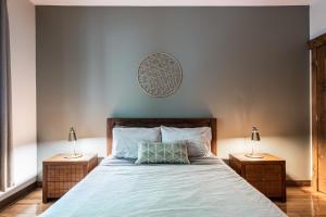 蒙特朗布朗Le Boisé (Les Manoirs) Mont-Tremblant的一间卧室配有一张大床和两盏灯