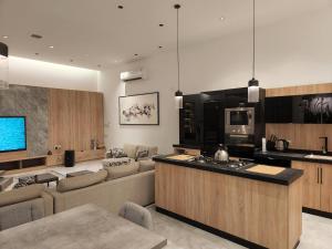 利雅德شاليه فاخر جداً جداً وخاص的厨房以及带沙发和台面的客厅。