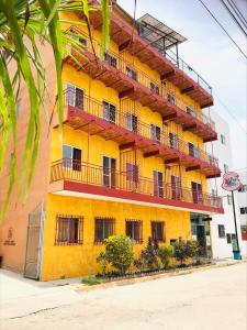 瓜亚比托斯Bungalows El Rincon de La Riviera的黄色的建筑,旁边设有阳台