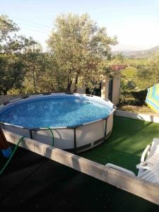拉梅戈Casa dos Copins的一个带两把椅子和遮阳伞的游泳池
