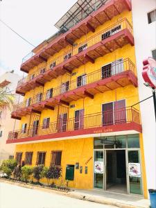 瓜亚比托斯Bungalows El Rincon de La Riviera的黄色的建筑,旁边设有阳台