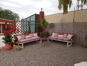皮萨拉Home Benitez Pizarra的庭院设有2张带粉红色枕头的长椅。