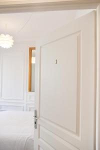 鲁昂Les Matelots Rouen Centre by MyFrenchPAT的一间白色卧室,卧室设有一扇通往一张床的门
