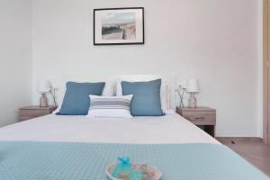 斯科派洛斯Esperides Apartments Aigli的一张带蓝色枕头的白色床和一个碗