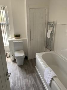 PontnewynyddMitchell Heights的白色的浴室设有浴缸和卫生间。