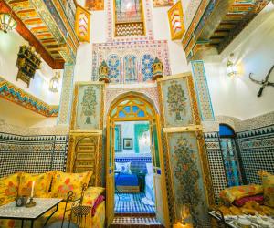 Fès al BaliPalais Fes Yahya的客厅设有色彩缤纷的墙壁和天花板。