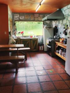 圣卡洛斯-德巴里洛切佩里科青年旅舍的厨房配有桌子、水槽和炉灶。