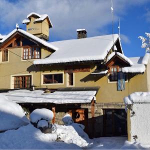 圣卡洛斯-德巴里洛切佩里科青年旅舍的雪覆盖的房子,有雪覆盖的屋顶