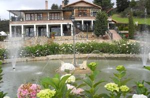 UbatéVilla Manantial de Sueños - Plan Pareja的池塘前有喷泉的房子