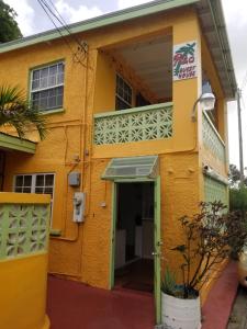 基督教堂市Rio Guesthouses的黄色的建筑,设有门和阳台