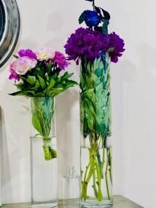 埃里温Grand Fortune Hotel的两个花瓶,桌子上放着鲜花