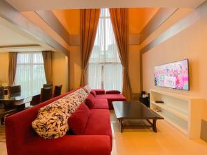 芭堤雅市中心Twenty Two Pool Villa的客厅配有红色的沙发和桌子