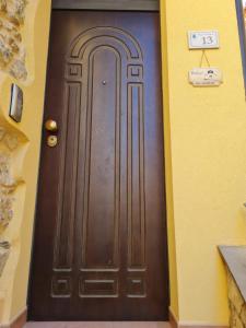 TrentinaraPalazzo B&B的建筑物内一扇棕色的门,上面有标志