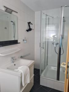 鲁斯特Badisch Home的带淋浴和盥洗盆的白色浴室
