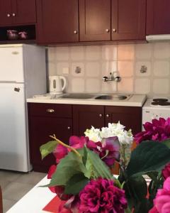 阿尔戈斯托利翁Barbara's one bedroom apartments的厨房配有紫色橱柜和桌子上的鲜花