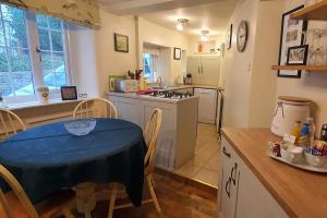 贝克韦尔Anne Cottage, Bakewell, in the Peak District的厨房配有桌子,厨房配有炉灶和桌椅