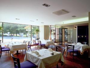 维尔扬迪维尔扬迪大酒店的餐厅设有白色的桌椅和大窗户