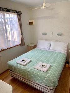 TaturaTatura Cabin & Caravan Park的一间卧室配有一张大床和毛巾