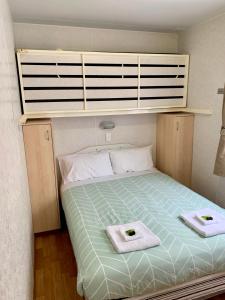 TaturaTatura Cabin & Caravan Park的一间卧室配有一张床,上面有两条毛巾