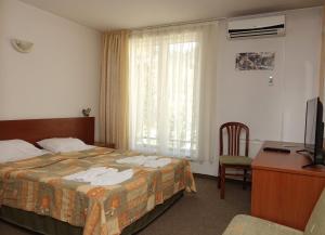 代温埃立特酒店的酒店客房配有一张床、一张书桌和一台电视。
