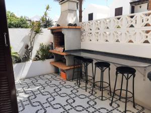 马赫Apartamentos Playa Honda的阳台的天井配有桌子和凳子