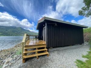 TresfjordFagervik Camping的水体旁的一座有楼梯的建筑