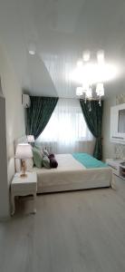 第聂伯罗Тиффани апартаменты的一间卧室设有一张大床和一个窗户。