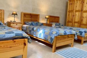 MunxarCountry View Residence的一间卧室设有两张床和木制橱柜。