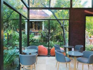 查龙Flora Ville-SHA PLUS的餐厅设有桌椅和大窗户。