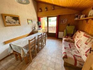 拉克吕萨Appartement La Clusaz, 3 pièces, 6 personnes - FR-1-459-32的客厅配有桌椅和沙发