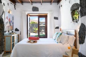 马赫La Casa del Medianero的一间卧室配有一张带白色床单的床和一扇窗户。