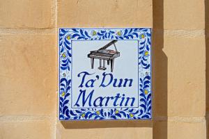 纳杜尔Ta' Dun Martin Bed and Breakfast的墙上的标牌上挂着钢琴