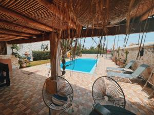 Ghazoua达马查酒店的一个带椅子的庭院和一个游泳池