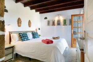 马赫La Casa del Medianero的卧室配有白色床和红色毛巾