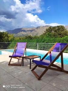梅洛Cabaña Negusa的游泳池畔的两把椅子和一张桌子