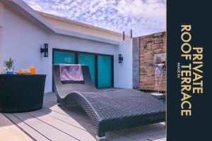 卡马拉海滩3 BR Stylish Condo with Private Rooftop Pool的庭院配有两把椅子和一张桌子