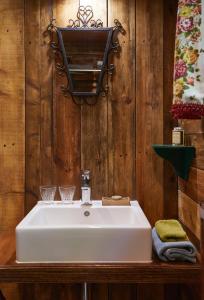 胡法利兹Tiny House Cetturu - 2-pers luxe en romantisch boshuisje的一间带白色水槽和木墙的浴室