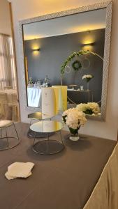 ColletortoPEDA Hotel Ristorante Pizzeria的一间设有两把椅子、镜子和鲜花的房间