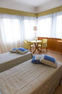 那不勒斯菲尤特拉会议中心酒店的配有两张床铺的酒店客房 - 带桌椅