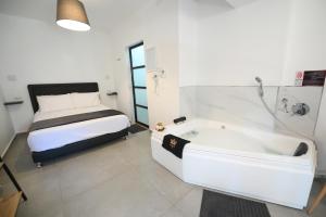 谢莫纳城Suites in the Galilee的卧室配有床和浴缸