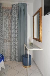 卡瓦德蒂雷尼Come a casa的配有桌子、镜子和窗帘的房间