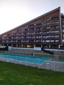 莱鲁斯Studio Le Lacuzon avec piscine et tennis extérieurs的一座建筑前面设有网球场