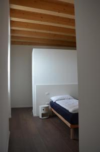 阿科Palazzo Oltre的一间卧室设有一张床和木制天花板