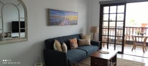 德尔锡伦西奥海岸Precioso apartamento con piscina junto al mar的客厅配有蓝色的沙发和桌子