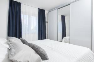 卡斯特尔·斯塔费力克Apartment Kiki的卧室配有带枕头和镜子的白色床
