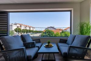 扎达尔Mrak Zadar Exclusive的阳台配有蓝色的家具和大窗户。