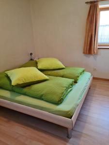 圣玛利亚瓦尔姆斯塔尔Lumpaz的一张带绿色床单和黄色枕头的床