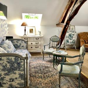 TaingyManoir de La Croix Saint Louis "Luxury Guest House"的一间卧室配有两把椅子、一张床和一张桌子